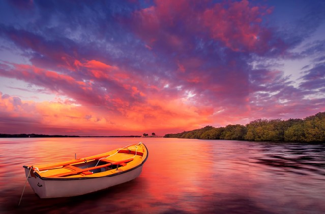 A rowboat watches an amazing sunset